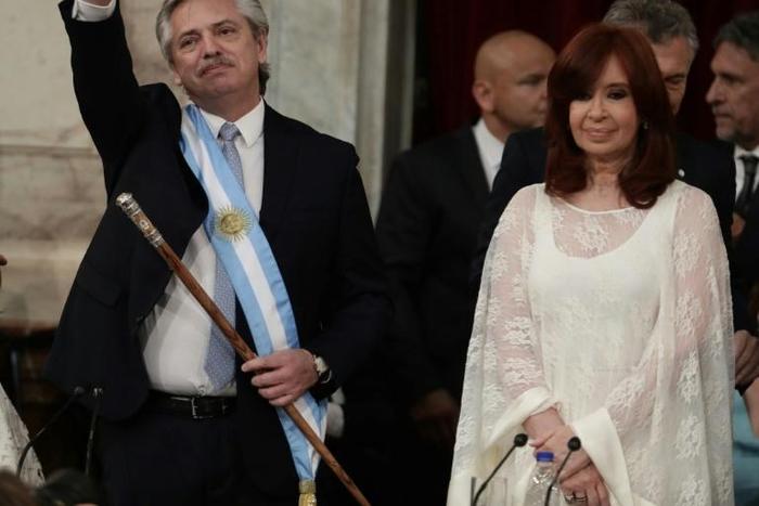 Argentina's new president, Alberto Fernandez, waves next to his vice-president Cristina Fernandez de Kirchner, after receiving the presidential sash from outgoing leader Mauricio Macri