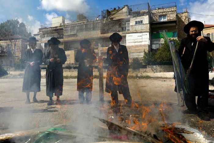 Jewish men burn food with leavening agents ahead of the start of Passover, in the the ultra-Orthodox Mea Shearim neighbourhood of Jerusalem