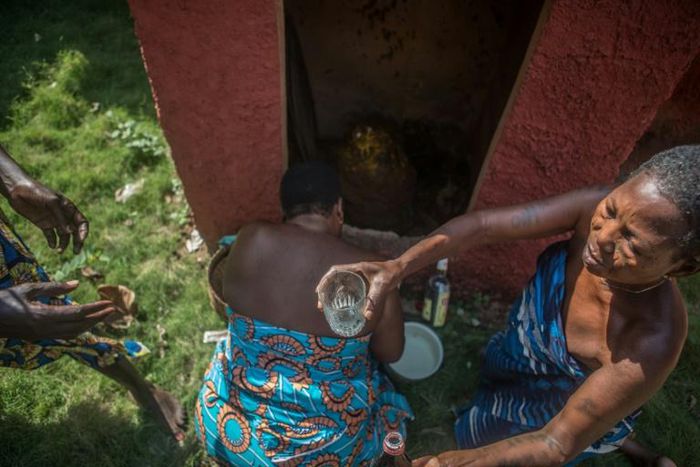Sacred: Priestesses in Porto-Novo give offerings to a voodoo idol
