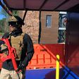 An armed officer stands outside of smoke-filled room during a media tour of a new training facility for US personnel overseas