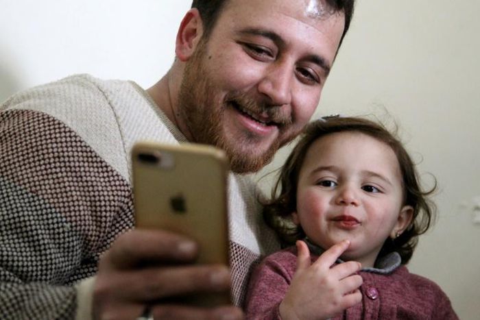 Syrian father Abdullah al-Mohammed with his three-year-old daughter Salwa. A video in which she laughs every time an explosion goes off was widely shared on social media as a heartening but grim reminder of Idlib residents' daily lives