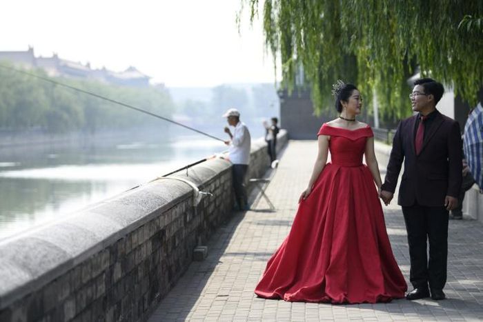 A couple pose for pre-wedding pictures at the north gate of the Palace Museum in Beijing