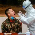 A medical worker takes a swab for testing from a Chinese paramilitary police officer in Shenzhen, Guangdong province