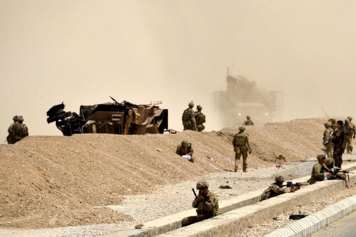 US soldiers are seen here keeping watch near the wreckage of their vehicle at the site of a Taliban suicide attack in Kandahar in 2017