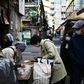 A woman in a face mask buys food from a vendor in Tokyo