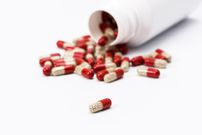 Many red and transparent medical capsules, filled with