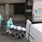 A health worker carries a body on a stretcher outside Gregorio Maranon hospital in Madrid