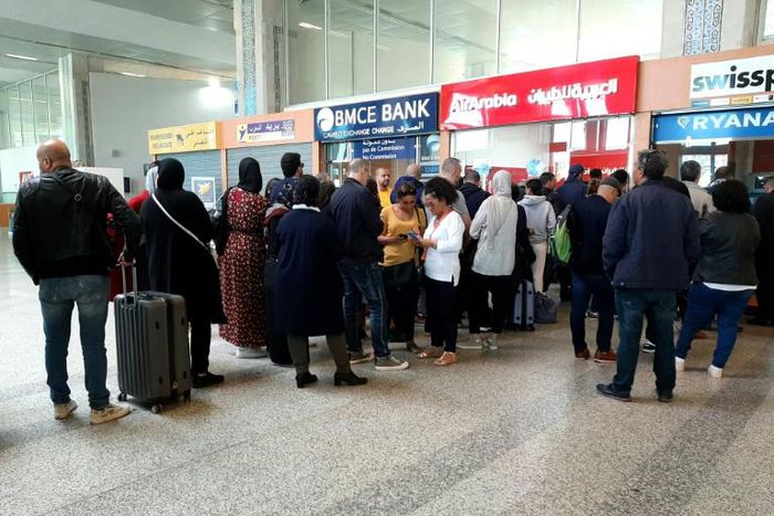 Passengers queue at the Ibn Battuta Airport in Tangiers, Morocco hoping to get a flight out of the country after it suspended links with Europe and other destinations over coronavirus fears