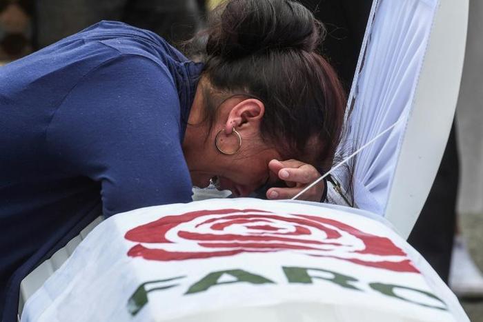 A relative mourns over the coffin of former FARC guerrilla Manuel Antonio Gonzalez on December 17, 2019, in Medellin, near the end of the deadliest year for the former Colombian rebels since a 2016 peace deal