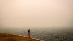 The barely visible Sydney Harbour Bridge is enveloped in haze caused by nearby bushfires