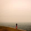 The barely visible Sydney Harbour Bridge is enveloped in haze caused by nearby bushfires