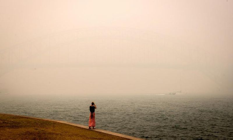 The barely visible Sydney Harbour Bridge is enveloped in haze caused by nearby bushfires