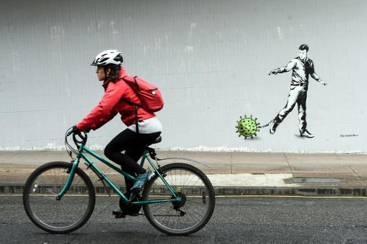 A cyclist passes  coronavirus-inspired graffiti in Glasgow on April 4, 2020, as life in Britain continues during the nationwide lockdown