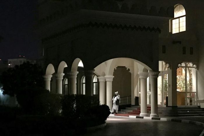A member of the Taliban negotiating team speaks on his phone outside the venue housing talks with US negotiators in the Qatari capital Doha last August