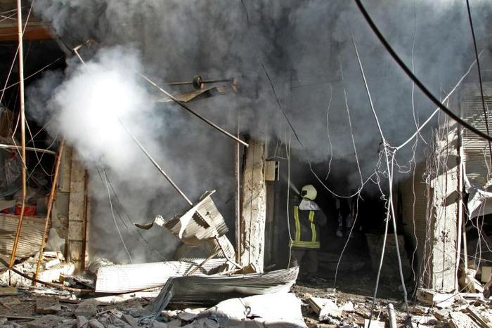 Smoke billows from a building following a reported bombardment by pro-government forces in Syria's Idlib province on December 20, 2019