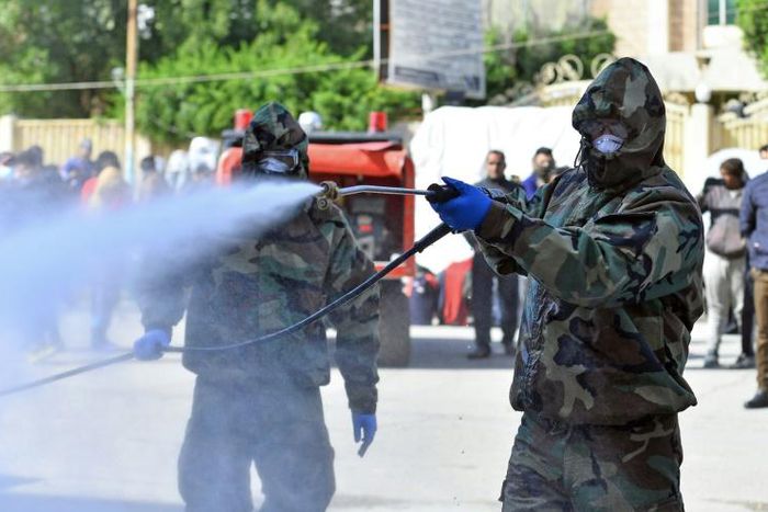 Civil defence teams disinfect a seminary in the Shiite shrine city of Najaf where Islamic students are believed to have come in contact with Iraq's first confirmed case of novel coronavirus