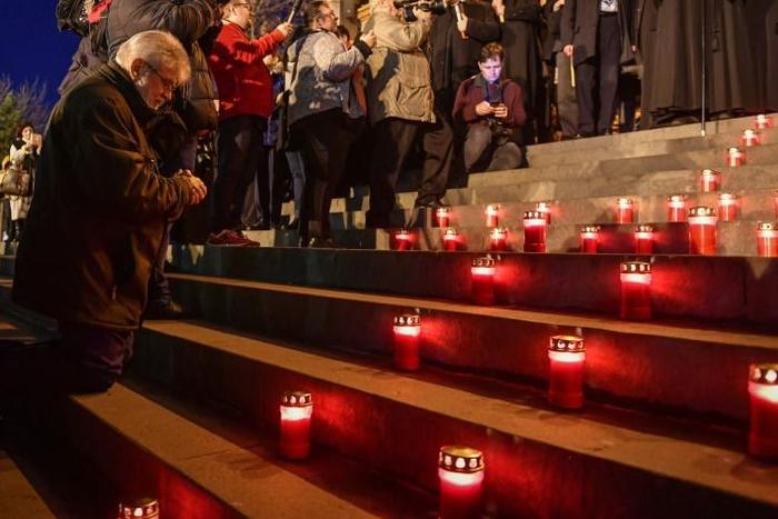 Un homme prie sur les marches de la cathédrale orthodoxe de Timisoara à l'occasion d'une marche au flambeau commémorant le début du soulèvement contre le régime du dictateur roumain Nicolae Ceausescu, il y a trente ans, à Timisoara (ouest), berceau de ...