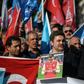 A supporter of China's Muslim Uighur minority holds a placard of Arsenal footballer Mesut Ozil during a demonstration in Istanbul