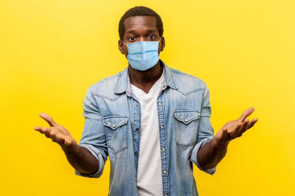 How could you. Portrait of unpleasantly surprised man with medical mask standing with raised hands and amazed face asking why'd you do that, indignant annoyed expression.