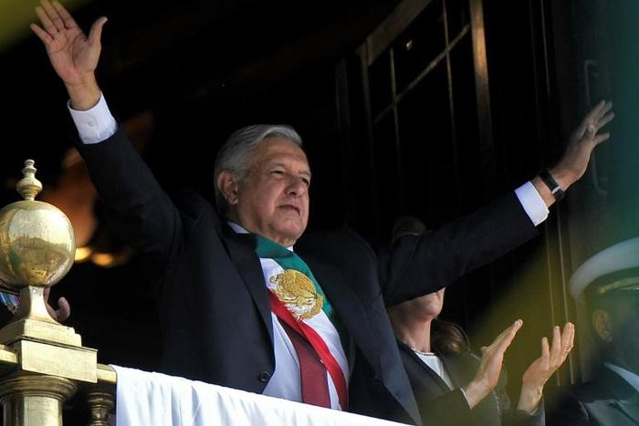 Mexican President Andres Manuel Lopez Obrador waves from the balcony of the National Palace during the anniversary of the Mexican Revolution in Mexico City on November 20