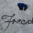 The English word "freedom" was spray-painted in cursive letters on a walkway
