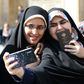 Iranian voters pose for a selfie during parliamentary elections at the Shah Abdul Azim shrine on the southern outskirts of Tehran on Friday