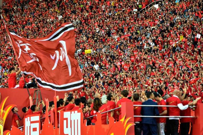 Fans of Guangzhou Evergrande cheer for the team after defeating Shanghai Shenhua to win the Chinese Super League (CSL) football championship in Guangzhou in China's southern Guangdong province in December