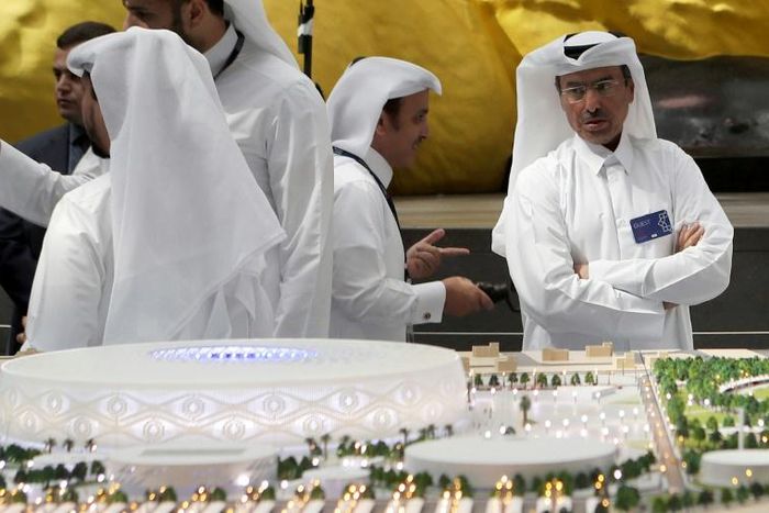 Qatari delegates look at a model of Al-Thumama stadium where two contractors have tested positive for COVID-19