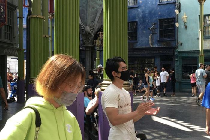 Tourists wear masks as they visit the Universal Studios theme park in Orlando, Florida, a state that is holding its Democratic presidential primary on March 17, 2020 despite widespread coronavirus outbreaks