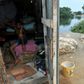A child remains inside his home as his relatives sit out the COVID-19 epidemic in Guayaquil, Ecuador's Nigeria neighborhood