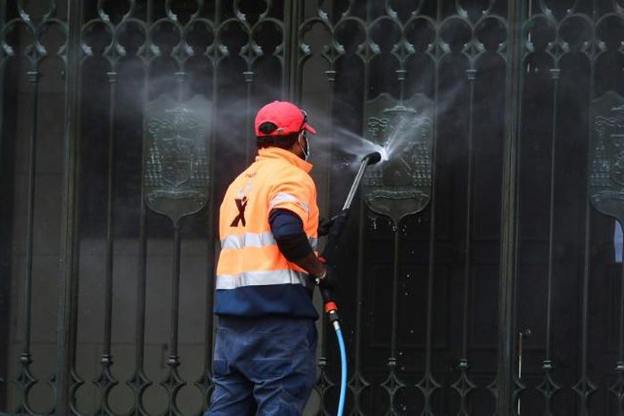 A worker cleans the entrance to St Patrick's Cathedral in Melbourne after it was vandalised following Cardinal George Pell's release from prison