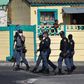 South African police patrol the street during clashes with residents (not visible) of Tafelsig, an impoverished suburb in Mitchells Plain, near Cape Town, on April 14, 2020, after some people in the community did not receive food parcels