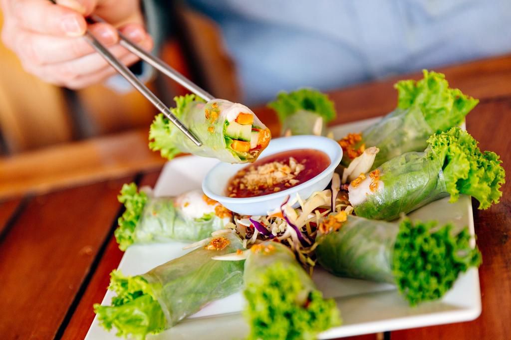 Holding fresh spring roll with chopsticks