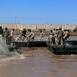 This file photo taken in 2017 shows international coalition forces and Iraqi soldiers installing a floating bridge at the Taji camp, north of Baghdad, during a training session