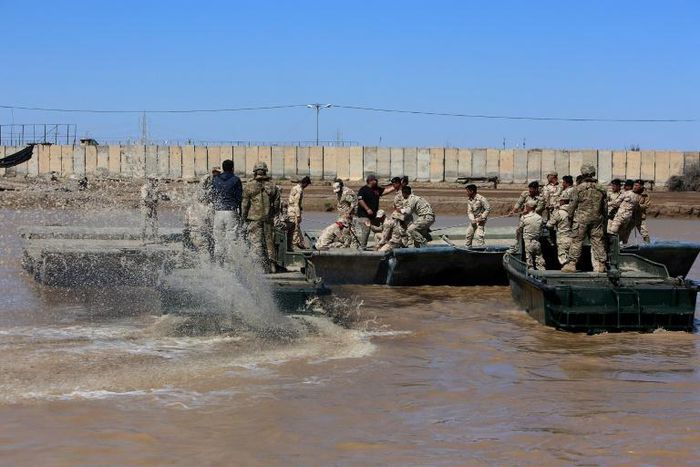 This file photo taken in 2017 shows international coalition forces and Iraqi soldiers installing a floating bridge at the Taji camp, north of Baghdad, during a training session