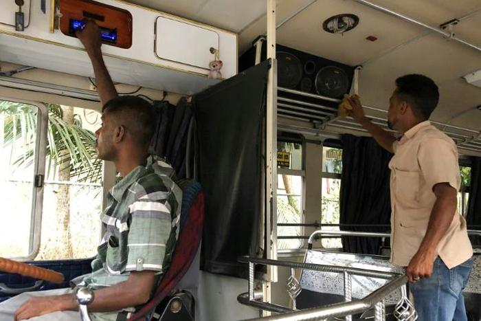 A driver and his assistant check and clean their sound system at the start of a journey in Biyagama, Sri Lanka. The government wants operators to turn down the volume on the notoriously loud vehicles