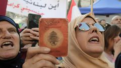 A Lebanese demonstrator holds up an old identity card during a march organised by the "My Nationality, My Dignity" campaign in Beirut