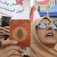 A Lebanese demonstrator holds up an old identity card during a march organised by the "My Nationality, My Dignity" campaign in Beirut
