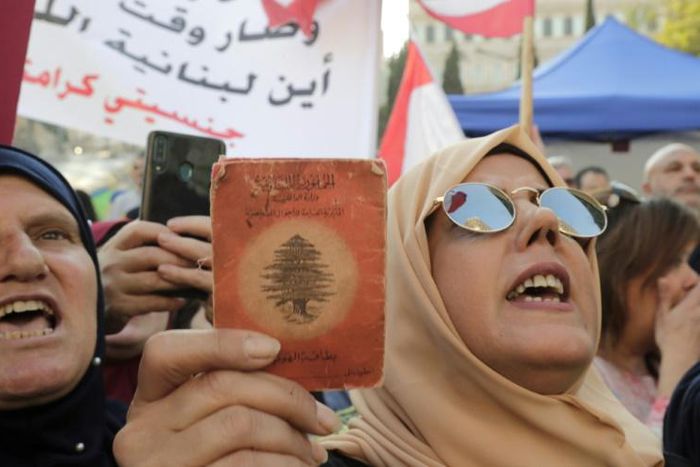 A Lebanese demonstrator holds up an old identity card during a march organised by the "My Nationality, My Dignity" campaign in Beirut