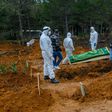 Officers and relatives prepare to bury a person who died from the coronavirus in Istanbul on March 27, at a cemetery opened by the government for victims of the COVID-19 pandemic