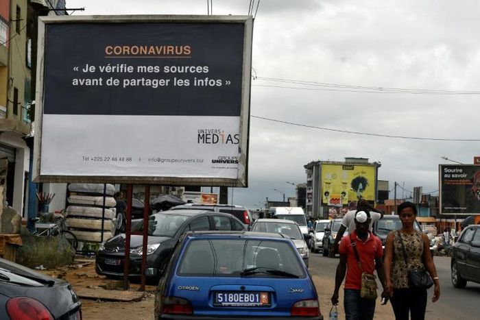 A sign in Abidjan reads 'Coronavirus - I check my sources before sharing news' to warn people against fake news and misinformation about the virus