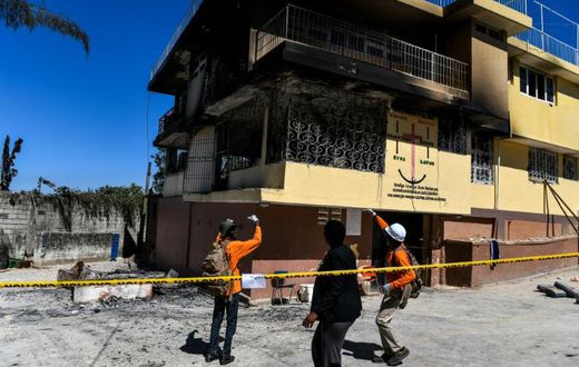 Firefighters speak to a local judge (C) as they point at the Orphanage of the Church of Bible Understanding where a fire broke out the previous night in the Kenscoff area outside of Port-au-Prince February 14, 2020