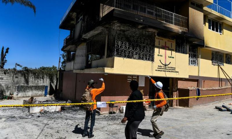 Firefighters speak to a local judge (C) as they point at the Orphanage of the Church of Bible Understanding where a fire broke out the previous night in the Kenscoff area outside of Port-au-Prince February 14, 2020