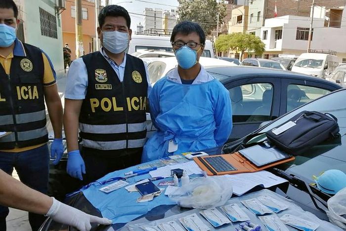 A Peruvian police photo showing Chinese citizen Zhang Tianxing (R) after his arrest for the unauthorized use of stolen COVID-19 tests in a street in Lima, on April 12, 2020