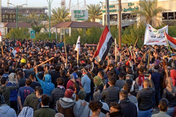Iraqi followers of influential cleric Moqtada Sadr (with batons) clash with protesters as they raid an anti-government protest camp in the central holy city of Najaf on Wednesday