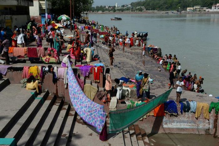 Indians dry their clothes after taking a holy dip in the River Ganges at Rishikesh, where about 700 foreign tourists remain as India's virus lockdown continues
