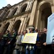 Protestors hold placards outside the court building as Australian Cardinal George Pell is escorted into the Supreme Court of Victoria in Melbourne on August 21, 2019.