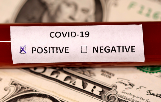 FILE PHOTO: A test tube labelled with the coronavirus is placed on U.S. dollar banknotes, in this illustration taken on March 1, 2020. REUTERS/Dado Ruvic