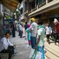 People wait in line to collect free rations from a government store during India's nationwide lockdown