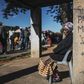 Informal traders and waste-pickers queue for food at a Soweto parking lot